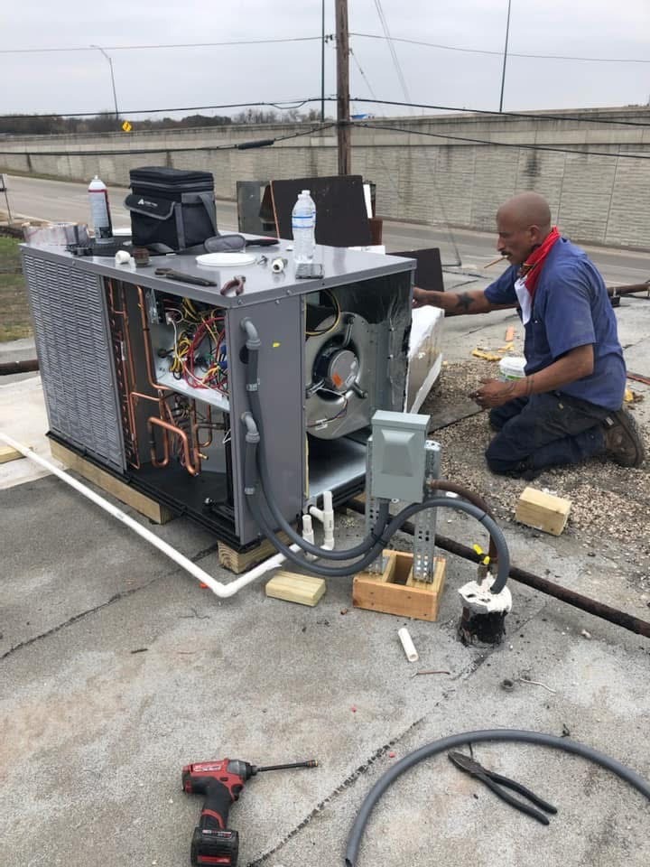 An Air Dynamics technician installing a new rooftop AC unit